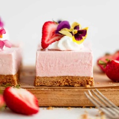 Cắt bánh ra thành miếng nhỏ và mời mọi người cùng thưởng thức nhé, bánh có thể trang trí bằng kem whipped và dâu tây tươi thái lát cho xinh nữa nè. Chiếc bánh mềm mại, dẻo quánh với vị chua của dâu tây, béo của phô mai nhưng không quá ngọt nhé, thật tuyệt vời.