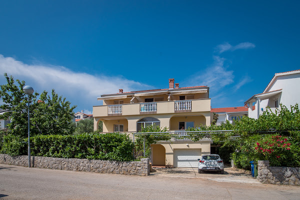 Exterior of the house with balconies, garage, and driveway.