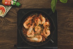Xếp những con tôm và tôm chiên vào chảo, đun liu riu khoảng 20-30 phút cho tôm ngấm đều gia vị. Vớt tôm ra tô. Hòa tan bột bắp với nước rồi cho vào chảo nước sốt, khuấy đều cho sệt lại, tắt bếp.