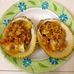 Tách sò ra làm 2, múc hành tím đã phi vào. Cho sò vào lò viba, quay khoảng 3-5 phút.