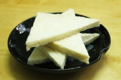 Cắt bỏ viền màu vàng của bánh mì sandwich, cắt làm đôi tạo thành hình tam giác.