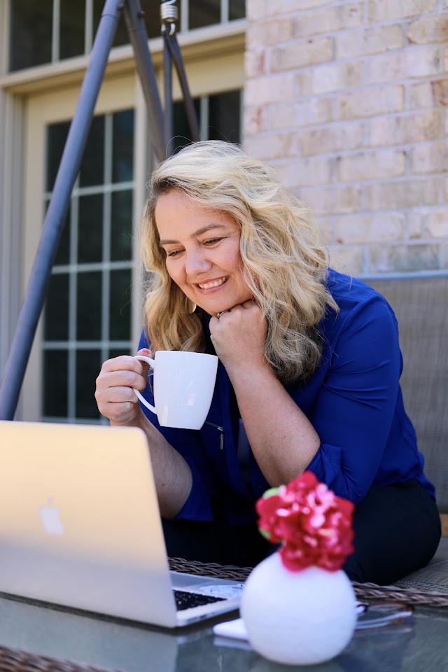 Tara smiling on a video call with her laptop and a cup of coffee
