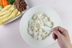 Vậy là đã chuẩn bị xong phần rau củ, trứng và thịt bò, bây giờ sẽ chuẩn bị phần cơm. Cho vào cơm nóng 1/2 muỗng cà phê muối, 1/2 muỗng cà phê tiêu, 1/2 muỗng cà phê đường, 2 muỗng cà phê dầu mè, 2 muỗng cà phê mè rang, trộn đều.