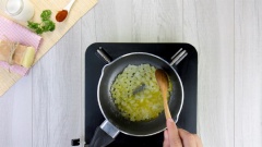 Làm sốt trộn mì. Đầu tiên cho vào nồi 20gr bơ lạt, đun cho bơ lạt tan chảy thì thêm 30gr hành tây cắt hạt lựu vào, xào cho hành tây thơm và chuyển trong. Tiếp theo thêm 15gr bột mì đa dụng, khuấy đều tay cho bột hòa tan vào với bơ và hành tây.