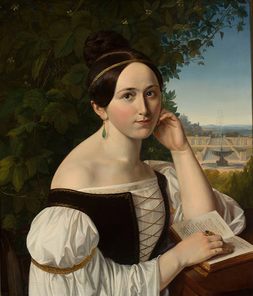 Portrait of a young woman with a book in a park