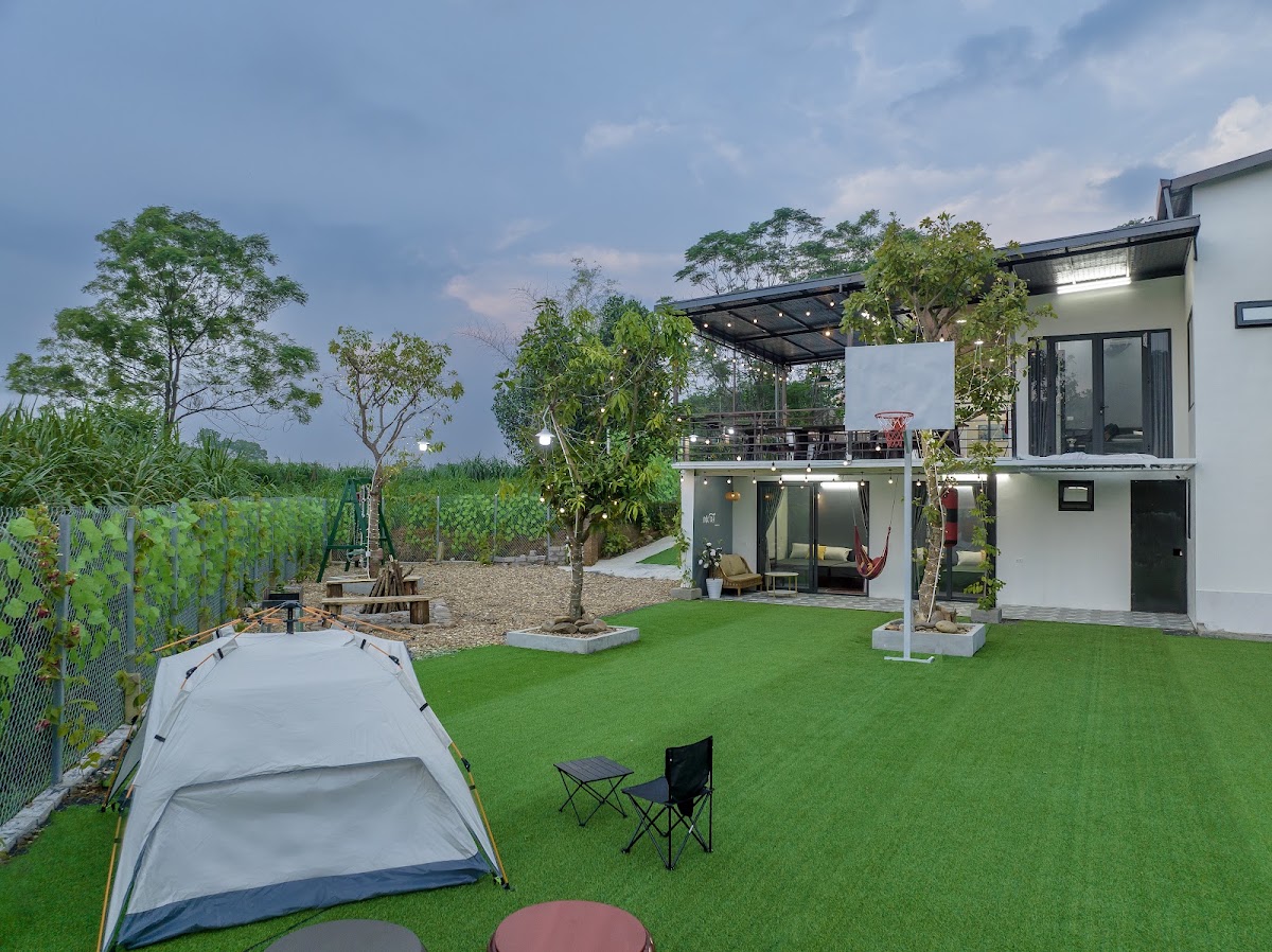 Sân cỏ rộng có cột bóng rổ trong khuôn viên Mộc Trà Homestay Ba Vì