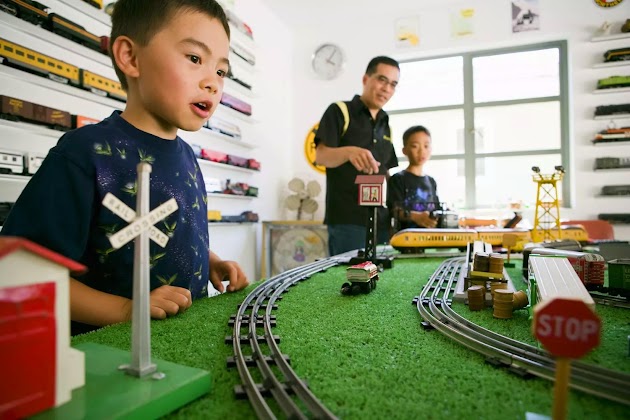 Vater und Söhne spielen mit Eisenbahn