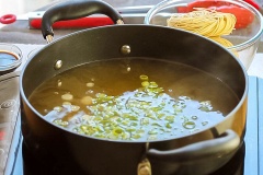 Rửa sạch cải thìa, cắt nhỏ. Hành lá rửa sạch, băm nhỏ. Bắc nồi nước dùng gà lên bếp, đun sôi, thả hành lá băm vào sau đó là cải thìa, khuấy khoảng vài giây thì bạn cho nước tương, hắc xì dầu và dầu hào vào.
