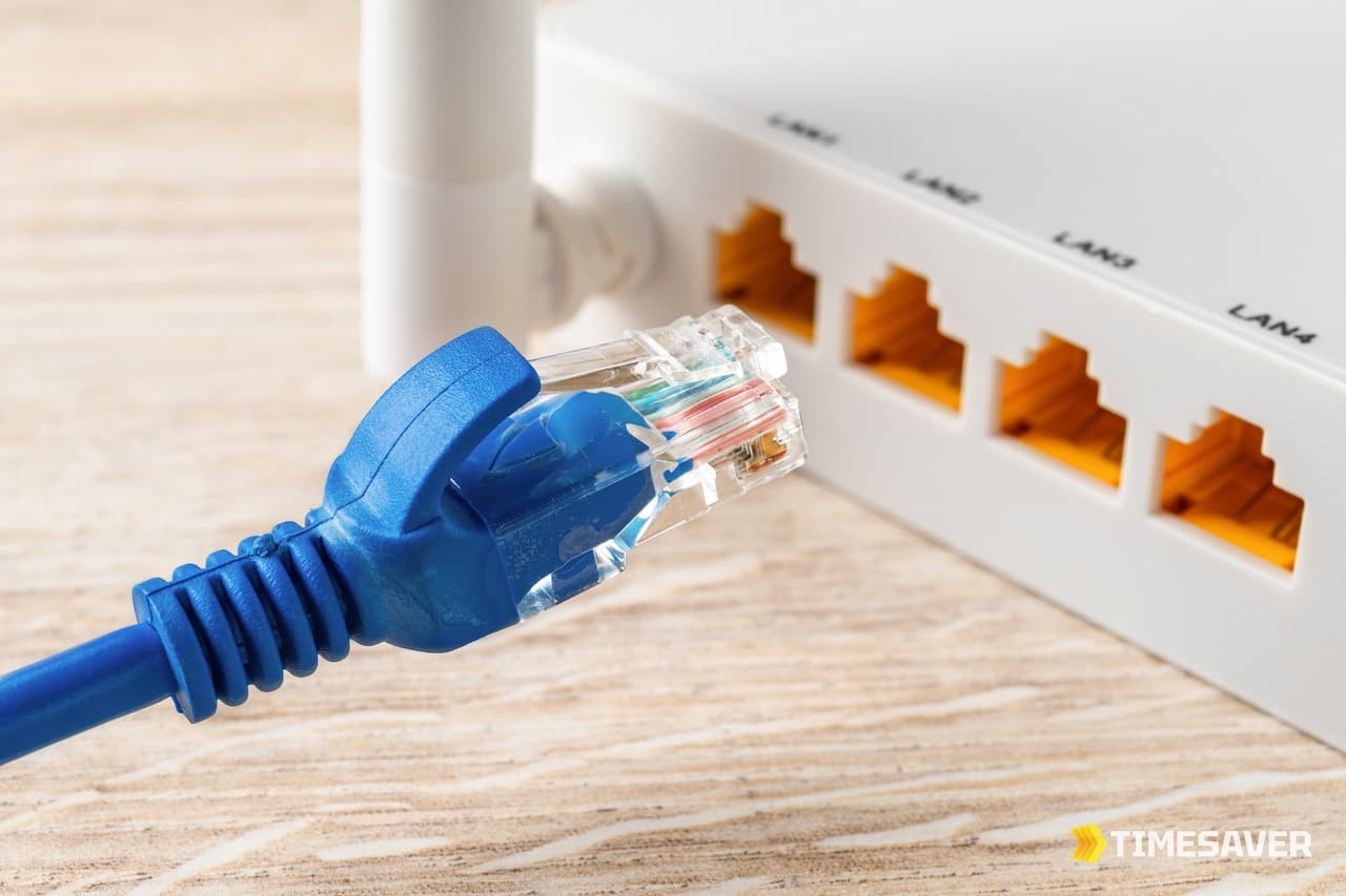 A blue Ethernet cable being plugged into a router's LAN port — Bungie recommends a wired connection over WiFi to fix Destiny 2 Error Code Bee