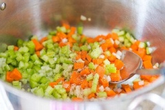 Hành tây, cần tây, cà rốt làm sạch, xắt hạt lựu. Cho nồi lên bếp, thêm dầu olive, cần tây, cà rốt, hành tây, 1/2 muỗng cà phê muối, và 1/2 muỗng cà phê tiêu đen vào đảo đều khoảng 10 phút cho tới khi rau củ trở mềm.