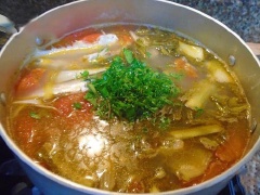 Phi thơm hành tím băm với 1 muỗng canh dầu ăn cho cà chua vào xào sơ. Cho dưa chua vào nồi cà chua xào khoảng 1-2 phút sau đó cho 1 bát tô nước vào đun sôi. Sau đó bạn thả cá vào đun nhỏ lửa cho cá chín mềm, ngọt nước, thêm 1-2 lát ớt hiểm cùng ít gừng băm nhỏ. Nêm nếm gia vị vừa miệng. Đun khoảng 3-5 phút nữa là được. Cuối cùng thêm ít hành, thì là thái nhỏ rồi tắt bếp.