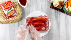 Sườn heo cắt làm thành từng cọng, đem ướp với 1 gói Thịt nướng vị Hàn Quốc - Xốt gia vị hoàn chỉnh Barona và 1 muỗng canh dầu ăn. Đeo bao tay xoa bóp đều từng miếng sườn để xốt ướp được thấm kỹ càng hơn.