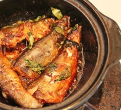 Cho cá vào nồi kho, rải rau quế xung quanh. Pha đường với 2 muỗng canh nước rồi cho vào nồi cùng với nước tương, dầu hào, nước màu. Kho lửa vừa đến khi nước cạn thì tắt bếp.