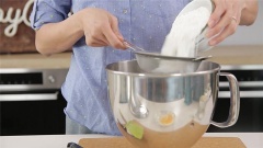 Bột mì và bột nở lọc qua rây cho mịn, đổ vào hỗn hợp trứng bơ đường, trộn đều. Thêm nước cam và một nửa phần vỏ cam đã băm nhỏ. Đánh đều tiếp.