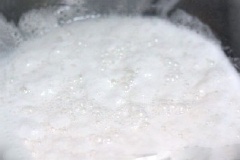 Đun và khuấy tan 200g đường với 200ml nước cốt dừa, để nguội rồi đổ hỗn hợp bột đã ủ. Bạn tiếp tục dùng màng thực phẩm bọc kín, ủ tiếp khoảng 3-4 tiếng đến khi bột sủi tăm lại.