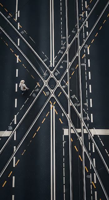 High-Angle Abstract View of a Solitary Pedestrian Walking on Wet Asphalt with Tram Tracks - Free mobile Wallpaper