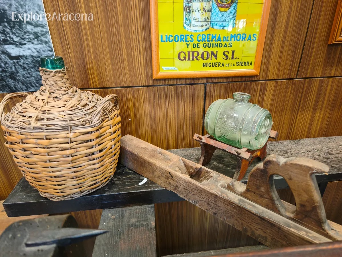 Historic distilling tools, bottles, and traditional containers displayed inside the Martes Santos museum near Aracena.