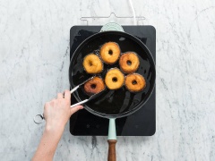 Bột làm bánh donut bạn có thể mua trong cửa hàng bán nguyên liệu làm bánh hoặc siêu thị nha. Bạn mua về, rã đông rồi dùng khuôn cắt phần trung tâm. Bắc chảo lên bếp, cho dầu ăn vào đun nóng, thả bột bánh vào chiên chín vàng 2 mặt.