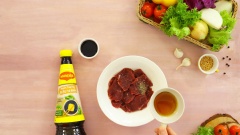 Rửa sạch 200gr thịt thăn bò, cắt lát mỏng. Ướp thịt bò với ½ muỗng cà phê tiêu, 1 muỗng canh mật ong, 1 muỗng canh nước tương Maggi trong 15 phút cho thấm gia vị.
