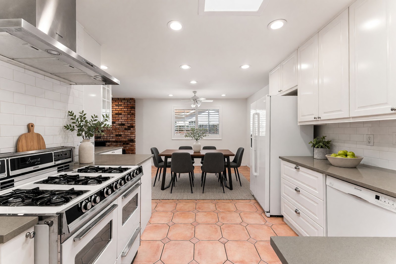 Kitchen with white cabinetry, quartz counters and gas range