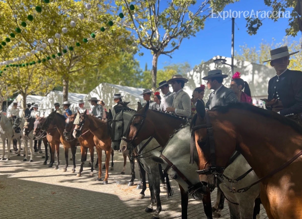 Riders in traditional equestrian clothing lined up on horseback during the Paseo a Caballo.