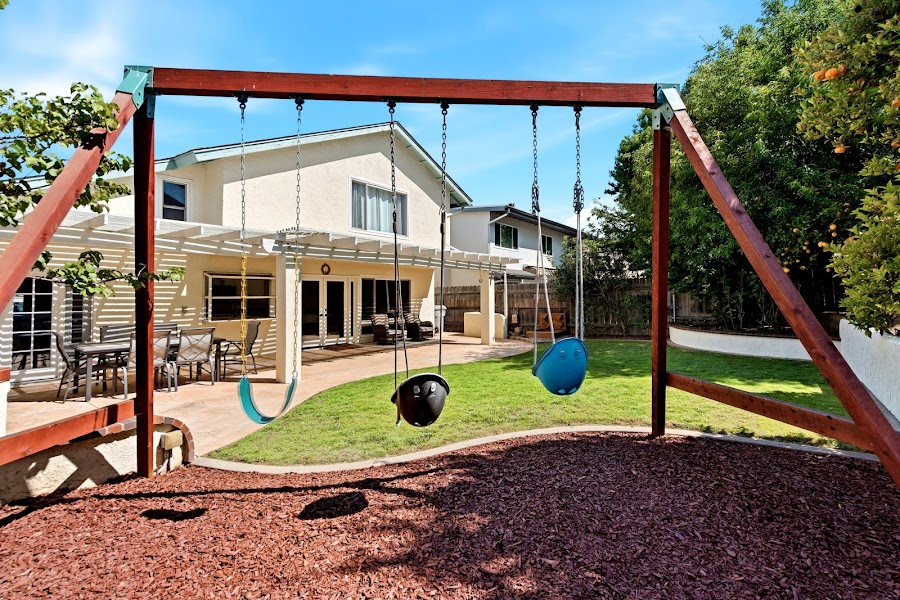 Backyard with swing set and outdoor entertaining space