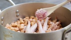 Cho hỗn hợp chân gà và đậu phộng đã ngâm vào nồi và bắt lên bếp. Sau đó cho thêm hành tím băm, muối, bột ngọt, dầu ăn, nước mắm.