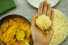 Phô mai Mozzarella cắt hạt lựu cho ra đĩa. Dùng tay vo tròn hỗn hợp, sau đó nhồi viên phô mai vào và vo đều lại. Tiếp đến lăn viên bí qua bột chiên xù.