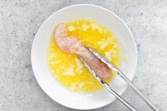 Thịt phi lê gà gà rửa sạch, khía nhỏ ở thân gà. Trứng gà đánh tan trong một bát riêng. Trong một bát khác, bạn trộn bột phô mai, bột chiên xù, bột tỏi, vụn bánh mì Panko. Nhúng thịt gà qua bát trứng gà, sau đó lăn qua hỗn hợp bột chiên xù.