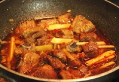 Thêm vào chảo sườn 2 muỗng canh nước mắm, 1 muỗng canh đường, ớt bột và nước màu, đun sôi.