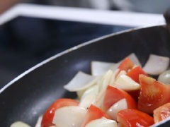Phi thơm tỏi, thêm hành tây vào xào nhanh. Tiếp đó cho cà chua vào xào trong 2 phút.