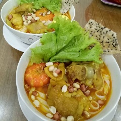 Cho sợi mì quảng ra tô. Chan đều nước dùng, thịt gà, móng giò heo vào. Rắc đậu phộng lên trên, ăn kèm bánh đa nướng và xà lách nhé! Thêm chút chanh để kích thích vị giác nào.