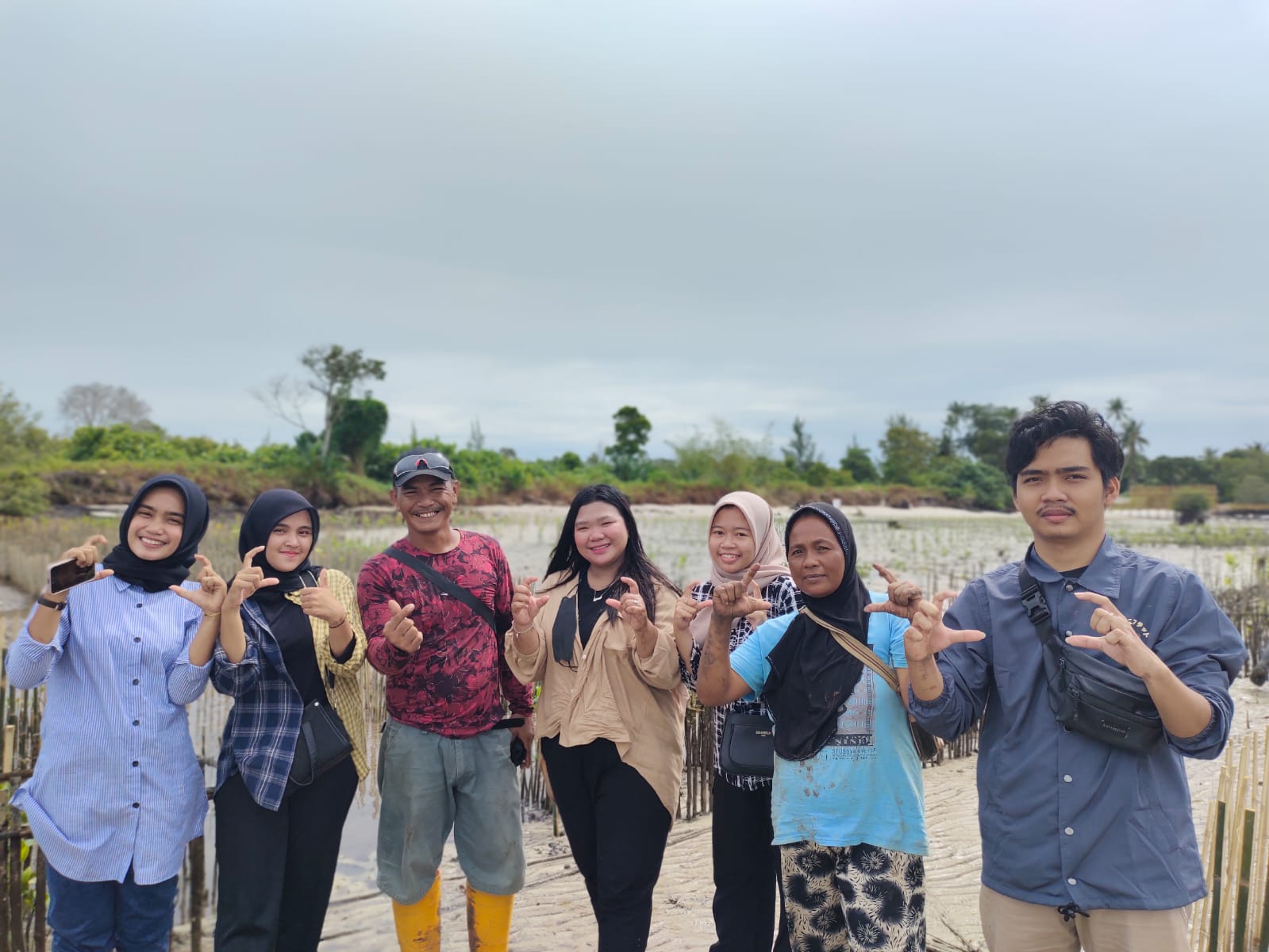 locals and teenage educators posing for a picture with C and love. Dompak island, blue carbon education, Indonesia coastal communities