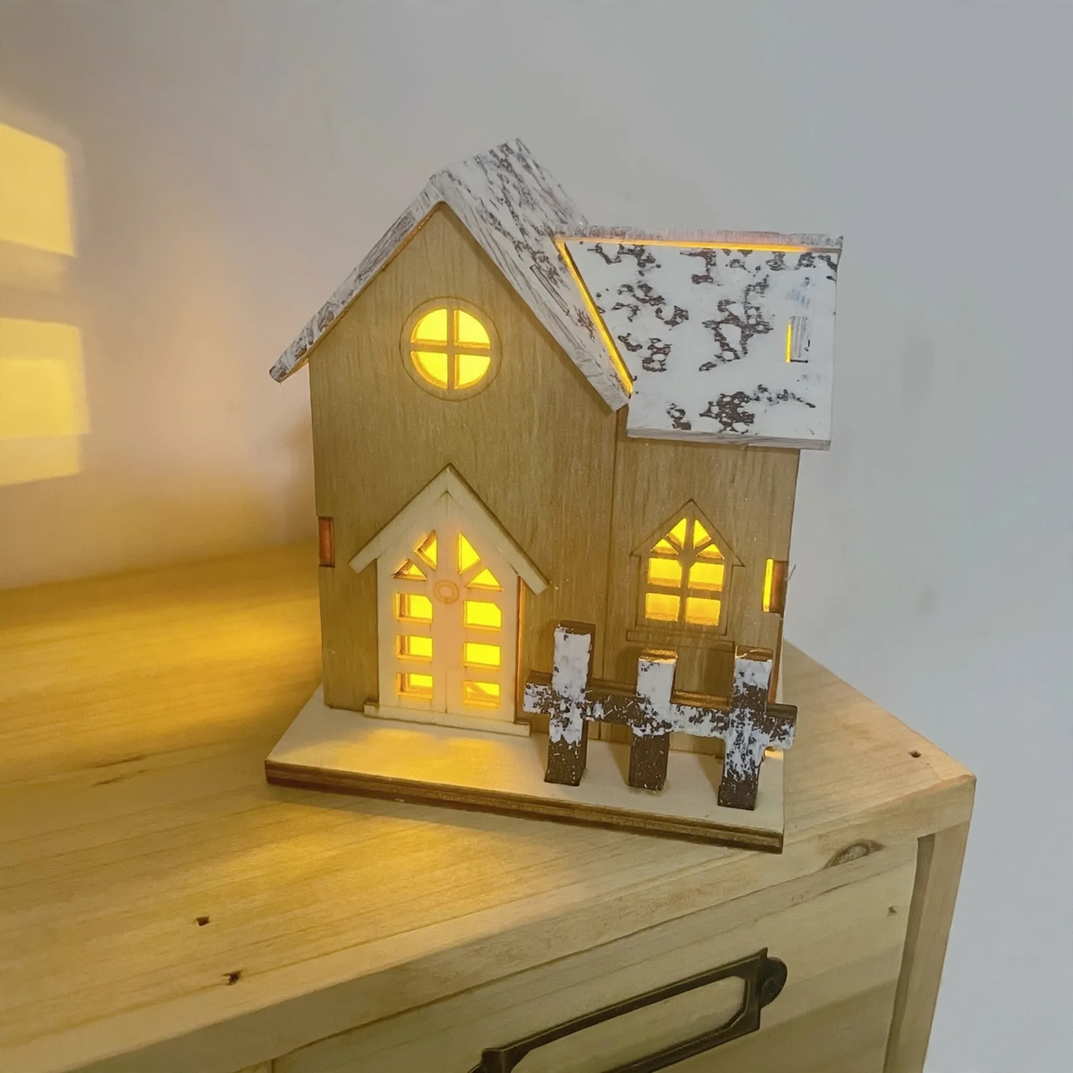 Illuminated Wooden Christmas House with Snowy Landscape