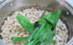 Cho đậu trắng vào nồi cùng lá nếp, 100g đường (hoặc cho lượng đường theo khẩu vị) và lượng nước cao gấp hai lần đậu. Đặt nồi đậu lên bếp đun sôi thì hạ lửa nhỏ. Ninh đậu sôi liu riu cho đến khi đậu chín mềm.