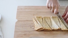 Ngâm bánh Tokbokki vào một bát nước. Thái khoanh hành lá và thái chả cá thành những miếng vừa ăn.