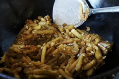 Đổ dầu ra khỏi chảo, giữ lại khoảng 3 muỗng canh, cho cà tím vào xào 1-2 phút, thêm khoai tây chiên vào. Nêm bột ngũ vị hương, muối, đường, sốt ớt đậu cay xào tiếp cho cà mềm thì tắt bếp, rắc thêm ít hành lá thái nhỏ.
