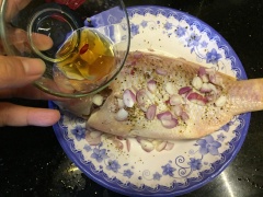 Cách làm cá hấp miến cuốn bánh tráng: Rửa sạch cá và làm cá thật kỹ để tránh mùi tanh, trước đó bạn cũng có thể ướp sơ qua chút muối. Cho cá lên dĩa đựng để lát đem đi hấp, cho tiêu, nước mắm, hành tím cắt lát rồi lần lượt xếp các nguyên liệu như miến, nấm mèo xung quanh cá. (Bạn có thể tùy tiện xếp miến và nấm mèo trên cá sao cho đẹp mắt là được). Thêm ớt cắt lát lên trên cho thơm.