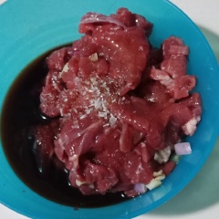 Cho thịt bò vào chén ướp cùng với 2 muỗng canh nước tương + 1/2 muỗng cafe bột ngọt + 1/2 muỗng cafe tiêu và cùng hành tím băm + tỏi băm. Trụng mì gói vào nước sôi, để ráo. Rửa sạch, cắt khúc rau muống, cải xanh, sau đó trụng nước sôi, để ráo.