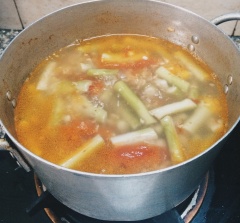 Nồi nước sôi, thả cà chua xắt múi cau vào. Khoảng 3 phút sau cho bồng khoai vào vặn lửa nhỏ, đậy nắp nồi, nấu cho đến khi bồng khoai mềm.