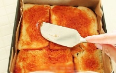 Phết đều sốt cà chua lên mặt trên của bánh trong khuôn.
