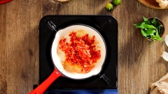 Làm ớt chưng miền Trung: bắc chảo lên bếp, đun nóng 1 muỗng canh dầu ăn, cho 20gr tỏi băm vào phi vàng, vớt tỏi ra chén để riêng. Thêm vào chảo 80gr ớt băm, 50gr đường trắng, 50ml nước mắm, khuấy đều rồi đun sôi lăn tăn. Đến khi hỗn hợp ớt keo lại thì cho tỏi phi vàng vào, trộn đều rồi tắt bếp.