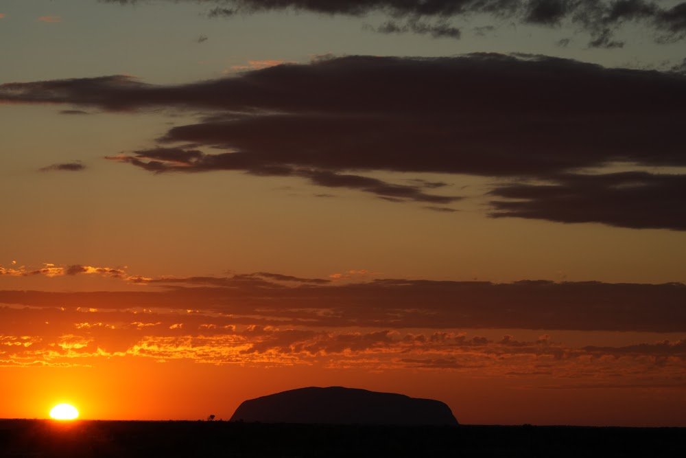 Uluru silhouette under an orange sky