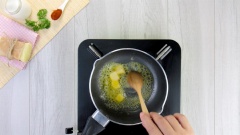 Làm sốt trộn mì. Đầu tiên cho vào nồi 20gr bơ lạt, đun cho bơ lạt tan chảy thì thêm 30gr hành tây cắt hạt lựu vào, xào cho hành tây thơm và chuyển trong. Tiếp theo thêm 15gr bột mì đa dụng, khuấy đều tay cho bột hòa tan vào với bơ và hành tây.