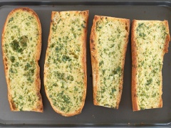 Bánh mì bổ đôi. Ngò rí rửa sạch thái nhỏ. Tỏi bóc vỏ băm nhỏ. Cho bơ, dầu olive, tỏi băm, ngò rí băm vào bát, cho tỏi vào tỏi trộn đều. Dùng muỗng phết hỗn hợp bơ tỏi vào miếng bánh mì. Xếp bánh mì vào khay rồi cho vào lò nướng nướng ở 180 độ C trong khoảng 10 phút hoặc cho đến khi bơ tan chảy và bánh đã giòn là được.