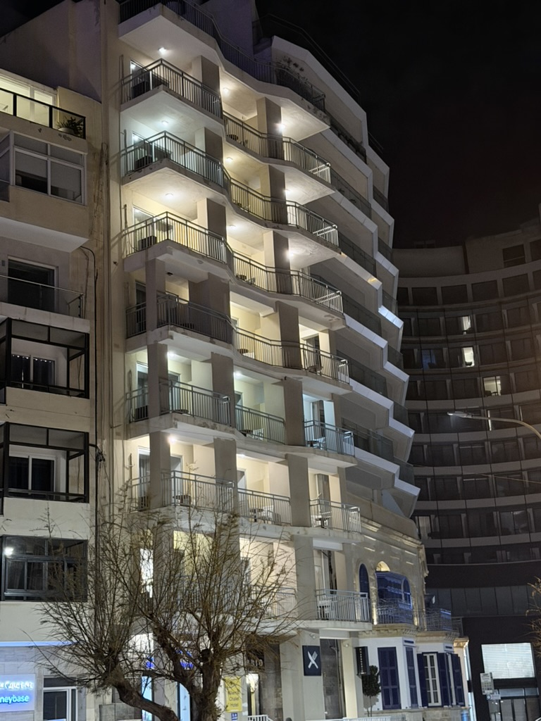Fachada iluminada del hotel en Sliema durante la primera noche