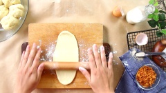 Sau khi bột ủ đủ, dùng tay đấm nhẹ cho xẹp khối bột và cho bột ra mặt phẳng nhồi khoảng 3 phút cho bột mịn. Tiếp theo chia bột thành những viên tròn nhỏ mỗi viên khoảng 50gr. Vê tròn viên bột, dùng cây cán bột cán dài mặt bột rồi gấp bột lại, lăn thành viên dài tạo hình cho bánh, sau đó đậy bánh lại, ủ kín đến khi bánh nở gần gấp đôi.