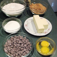 Mở trước lò nướng ở 170 độ C (325 độ F). Đặt giá ở giữa lò nếu là lò nhỏ, hoặc 1 giá phía trên (còn chừa 1 nấc trên cùng), 1 giá phía dưới (còn chừa 1 nấc dưới cùng) nếu là lò lớn. Lót giấy chống dính vào khay. Trộn đều 300g bột mì, 1/2 muỗng cà phê muối, 1/2 muỗng cà phê muối nở (baking soda). Để sang 1 bên. Dùng máy đánh đều 170g bơ mềm và 2 loại đường cho đến khi chúng thật hòa quyện. Cho tình chất vani và trứng vào (chia làm 2 lần), khuấy thật đều. Chế hỗn hợp bột vào, trộn thật đều (dùng máy thì đánh ở tốc độ thấp nhất khoảng 20 giây). Dùng phới trộn chocolate chip vào hỗn hợp.