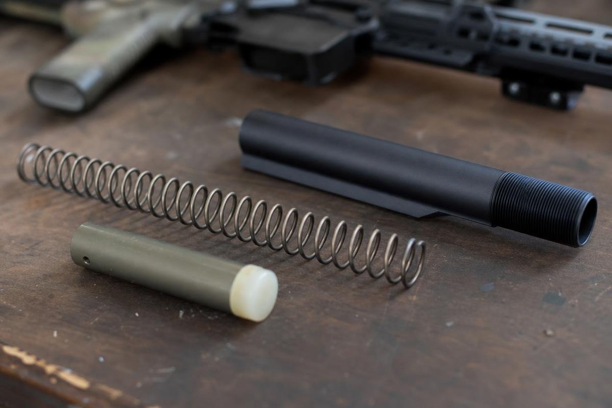 Carbine buffer, mil-spec buffer spring, and receiver extension laid out for assembly