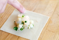 Cho tôm, hành lá, gừng, dầu mè, nước tương, tương ớt và muối vào một bát lớn rồi trộn đều. Sau đó, bạn để ướp khoảng 15 phút. Trải lá hoành thánh ra, cho nhân tôm đã được ướp vào. Bạn thấm một ít nước hoặc trứng ở mép lá hoành thánh để dính dễ hơn.